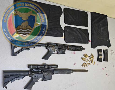 During a joint intelligence operation by CANU officers on July 19, 2024, two AR-15 rifles, matching magazines, 25 cartridges, 7.62 rounds, and a bulletproof vest were found in an abandoned residence in Lower East Coast Demerara.